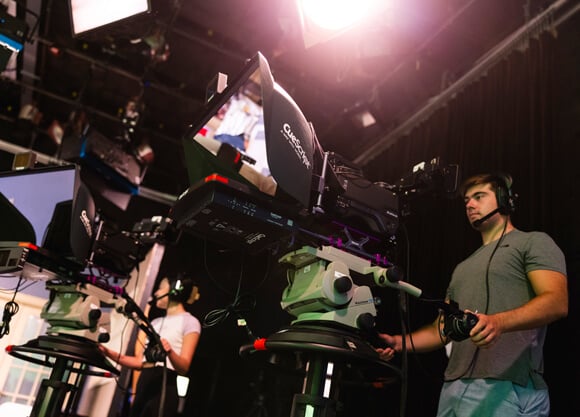 Quinnipiac student operates a camera in the McMahon Center production room.