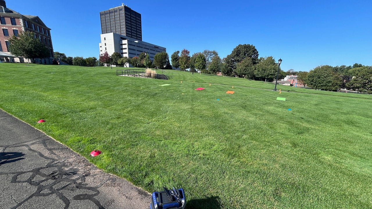 Wide open field with two yoga mats laying in the grass.