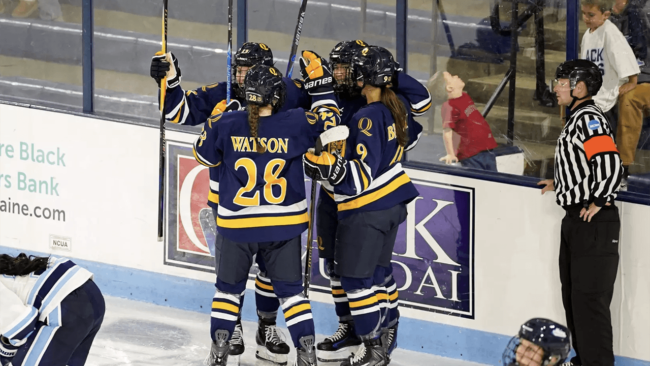 Women's ice hockey players in a huddle.