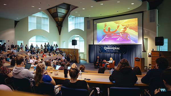 Mattel CEO Ynon Kreiz speaks to Quinnipiac President Judy Olian and an overflow crowd at the Mount Carmel Auditorium