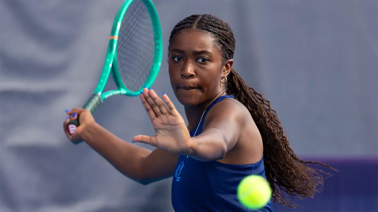 A tennis player prepares to hit the ball with their racket.