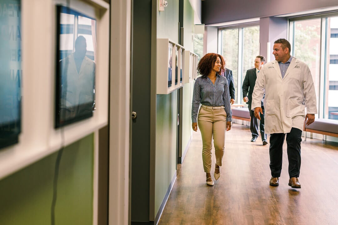 Healthcare officials walking through a hallway.