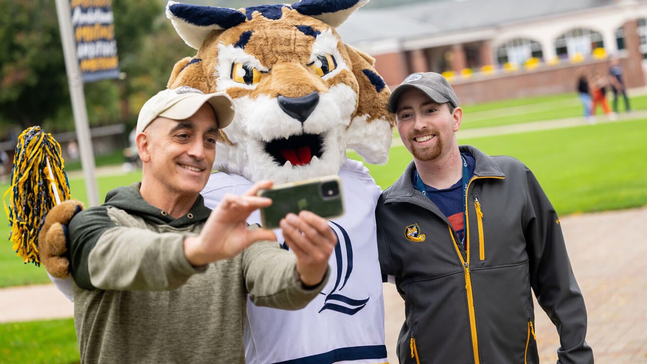 Men take selfie with Boomer the Bobcat