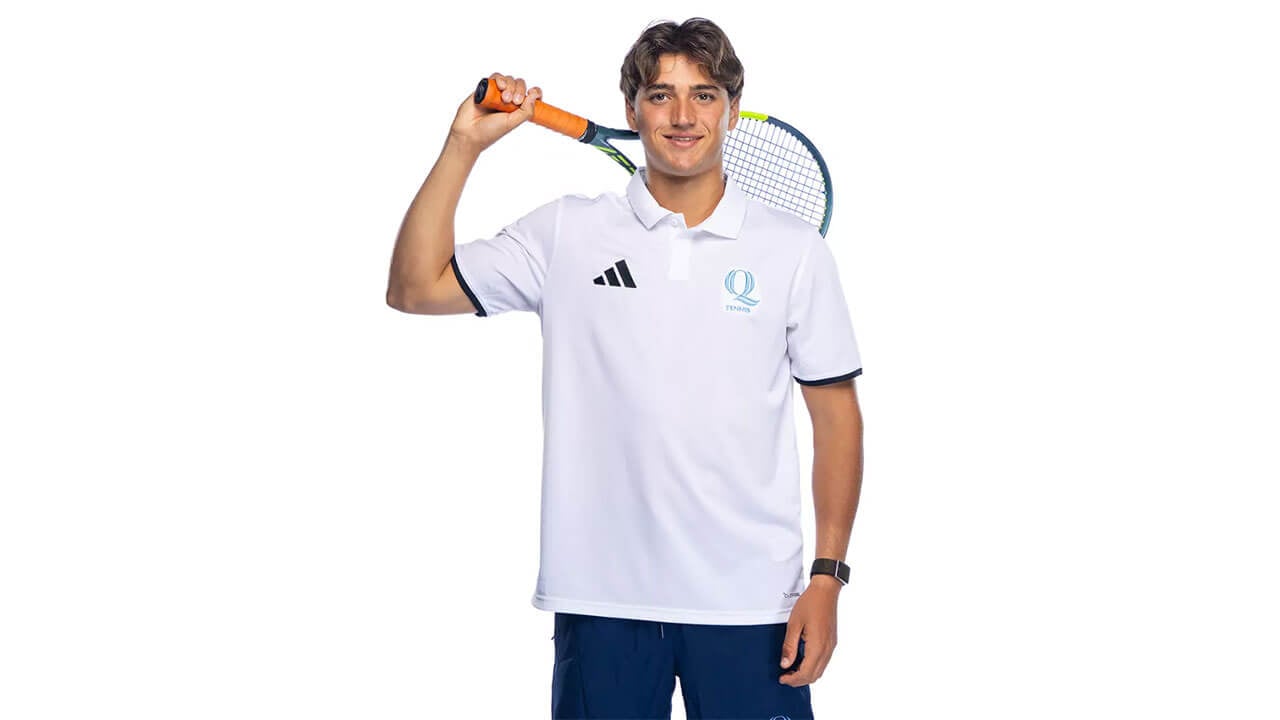 Member of the men's tennis team poses with his racket behind his head.