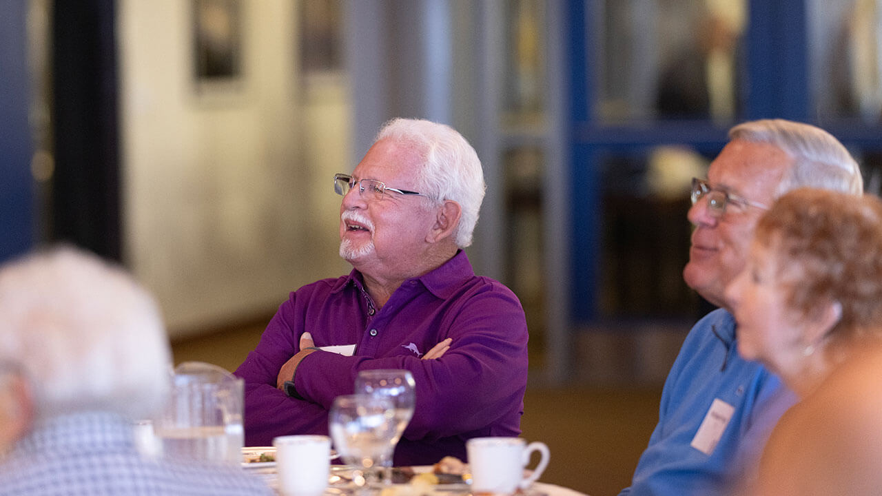 Alumni smiling while listening to a speaker at the Alumni Heritage Luncheon