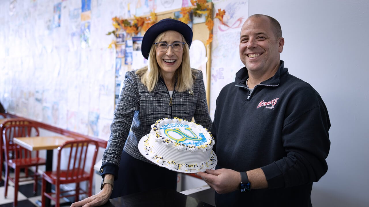 Brian Anderson and Marie Hardin pose with a custom Quinnipiac ice cream cake