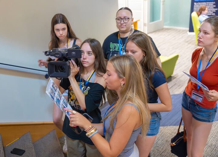 High school students collaborating to frame a shot on a UX-90 camera while consulting a shot list during Quinnipiac University’s Movie Making Summer Camp.