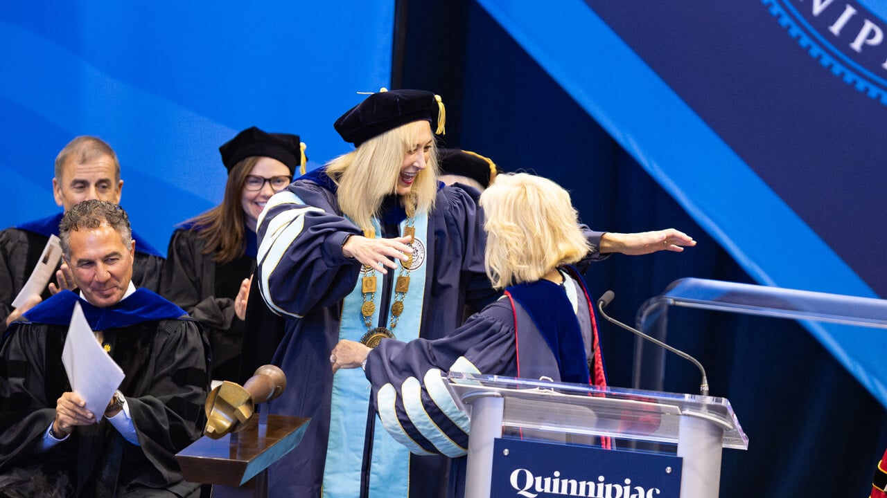 Marie Hardin and Judy Olian embracing on stage