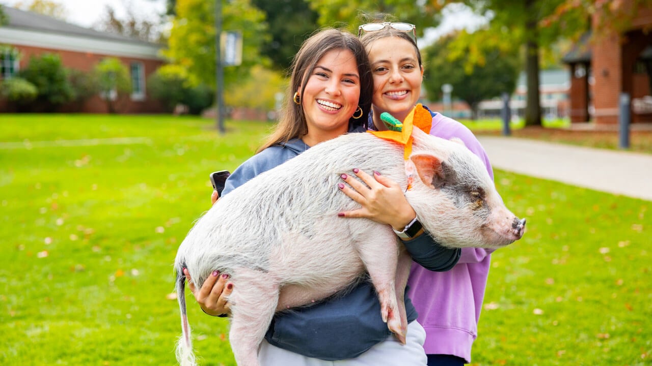 Students pose with a pig