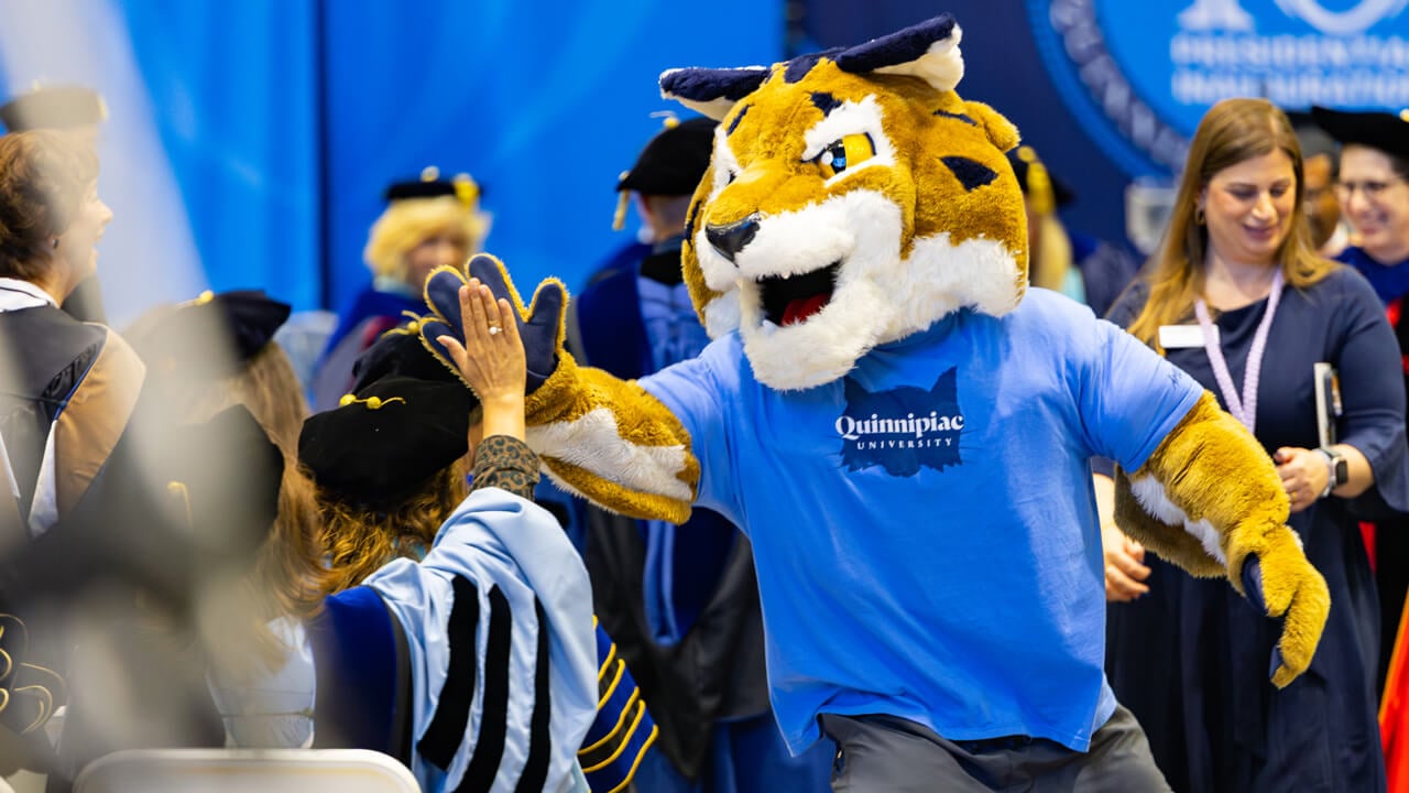 Boomer high fives seated audience members as he walks up the aisle