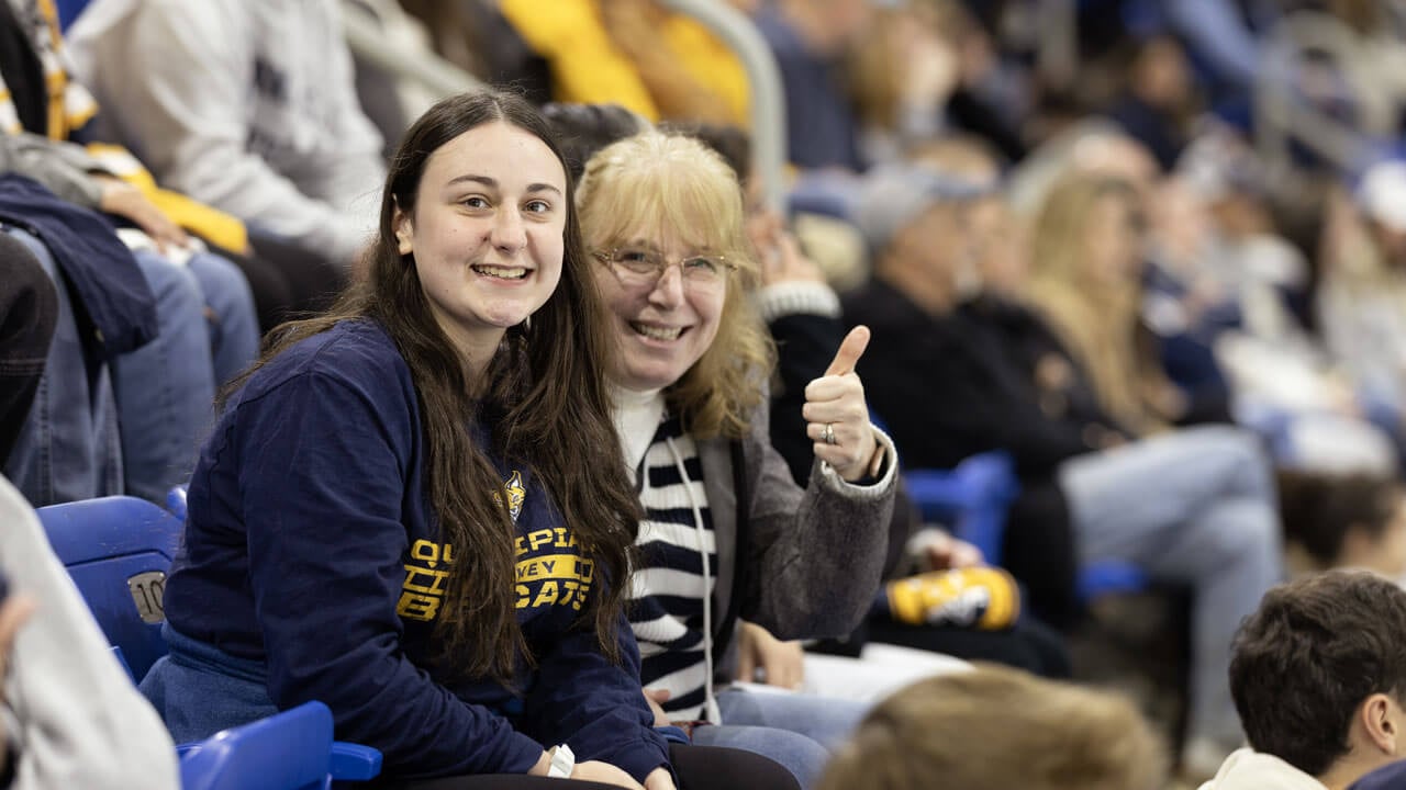 Mom and daughter smile at Quinnipiac mens ice hockey game