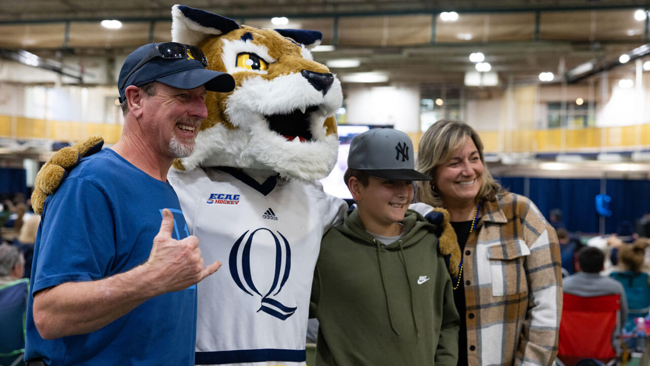 Family of three pose for a photo with Boomer the Bobcat