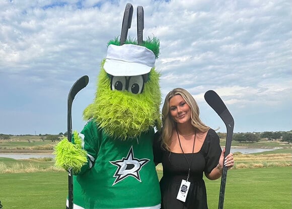Tyra standing with the mascot of the Dallas Stars.