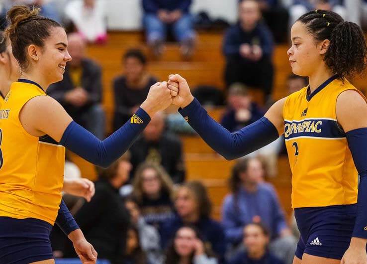 Two volleyball players fist bump
