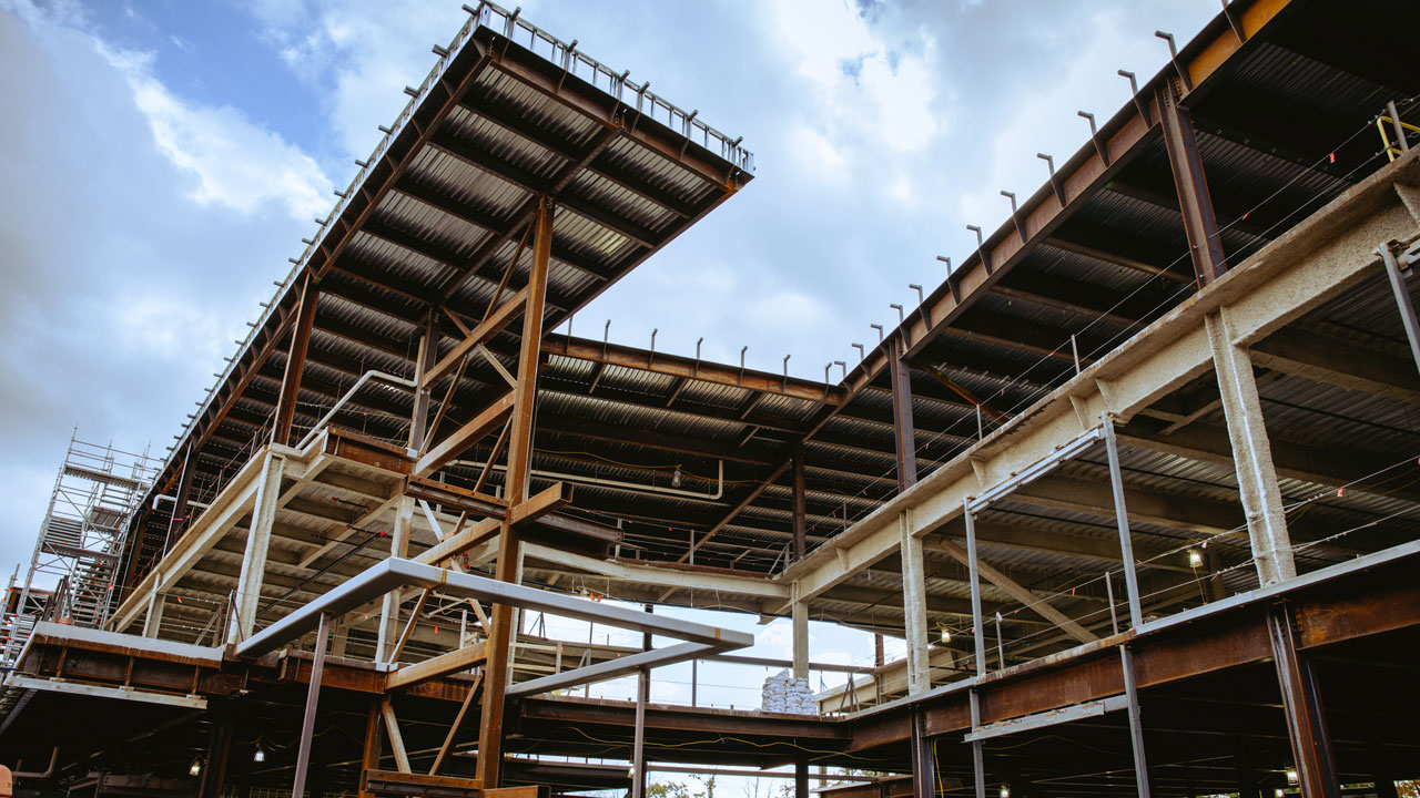A view of the new south quad construction from below with beams and platforms towering over.
