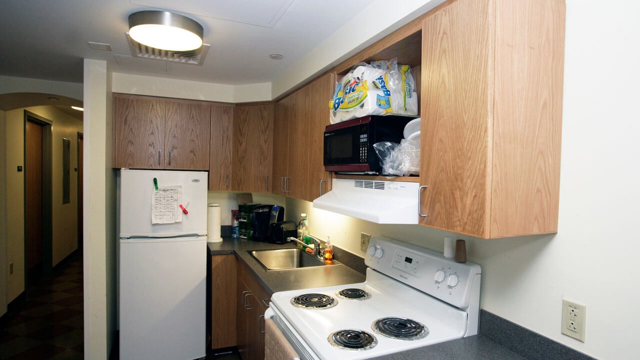 Eastview kitchen accompanied with a stove, fridge, and sink