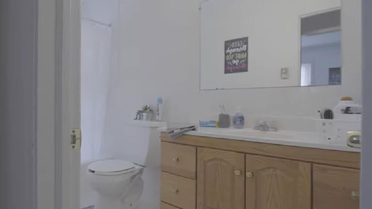 A bathroom with a bathtub, sink, and toilet in Whitney Village apartment Complex