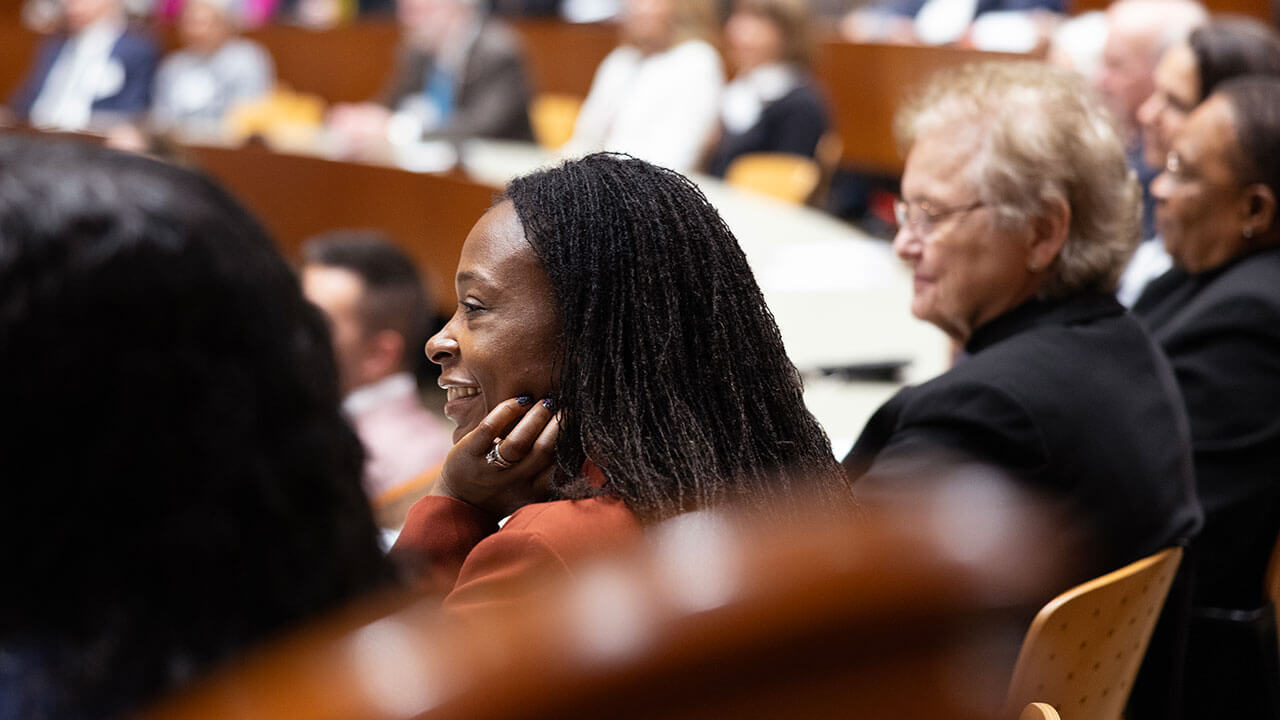 A woman sits in the Quinnipiac School of Law courtroom and listens to a speaker