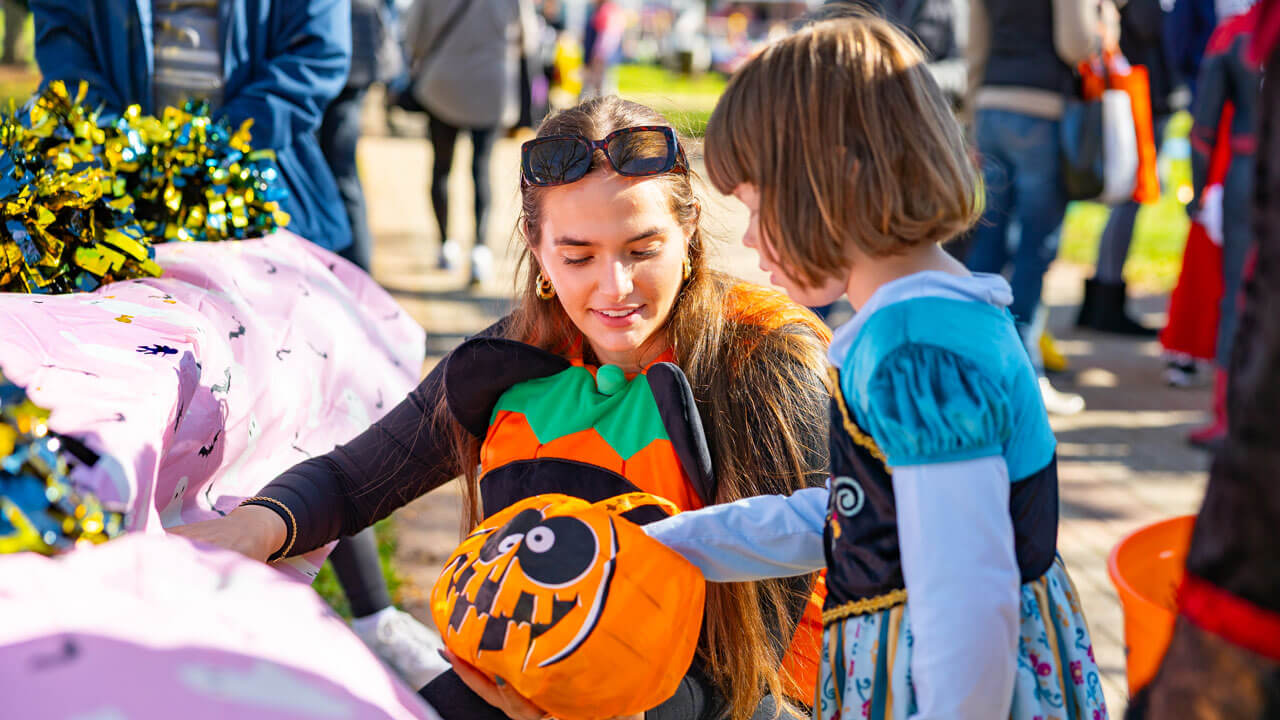Child reaches into a pumpkin for a prize