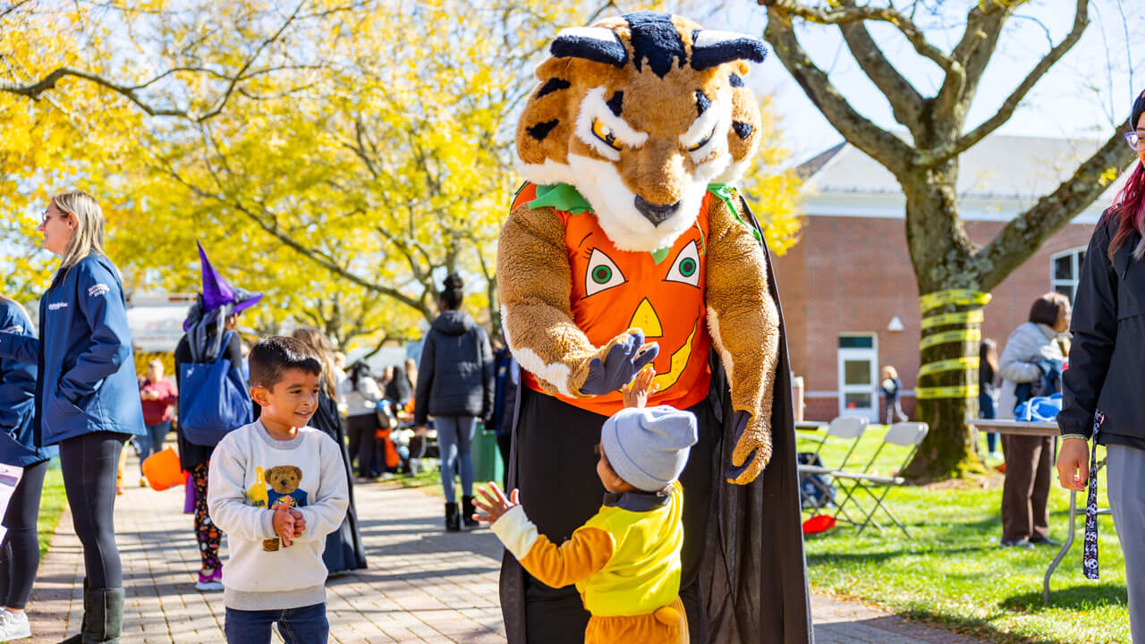 Child runs up to Boomer for a high five