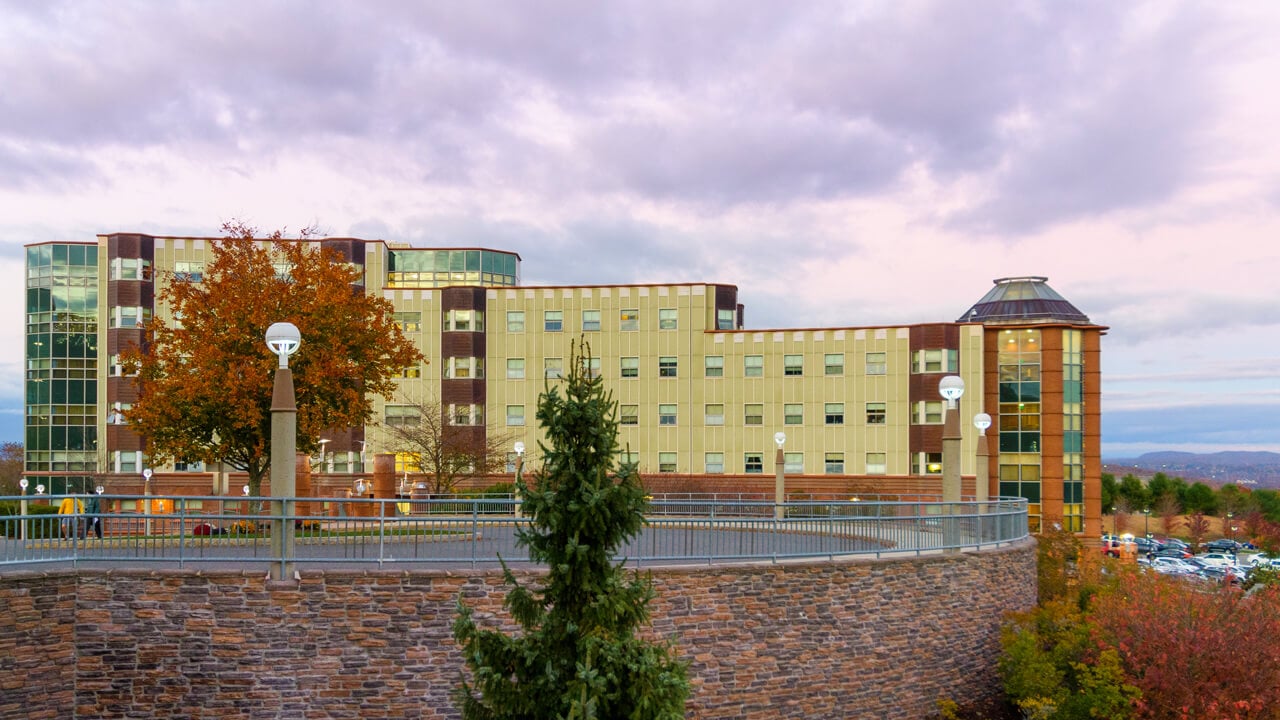 View of Eastview residence hall at sunset with the New Haven skyline in the background