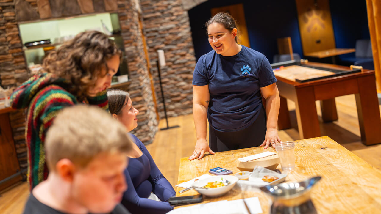 An On the Rocks crew member at a table of people