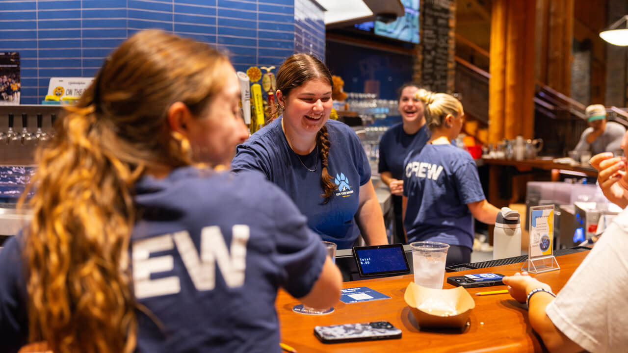 3 students working at the bar at On the Rocks