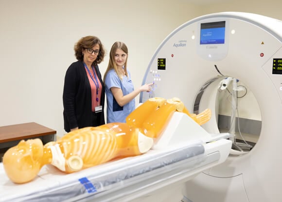 Health sciences student performs a diagnostic imaging procedure on a mannequin.