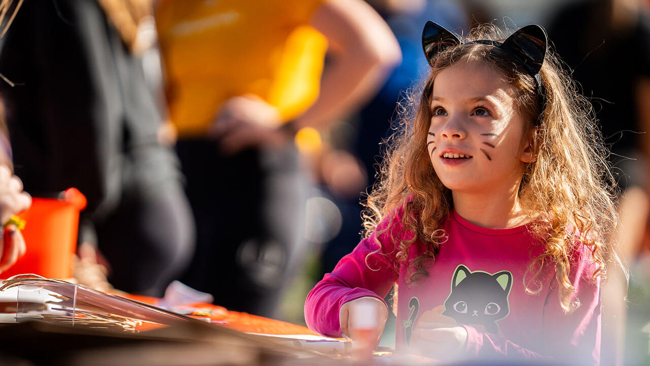 Little girl in cat ears enjoying arts and crafts