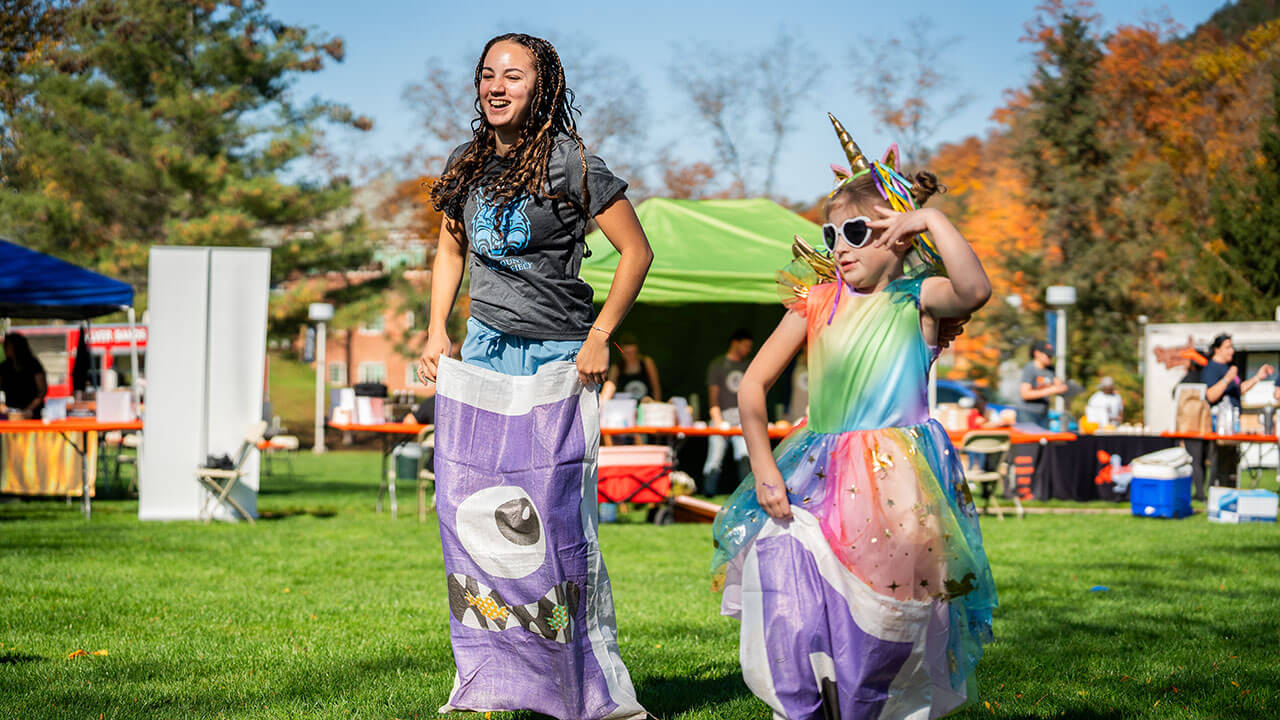 A little girl dressed as a unicorn taking part in a sack race