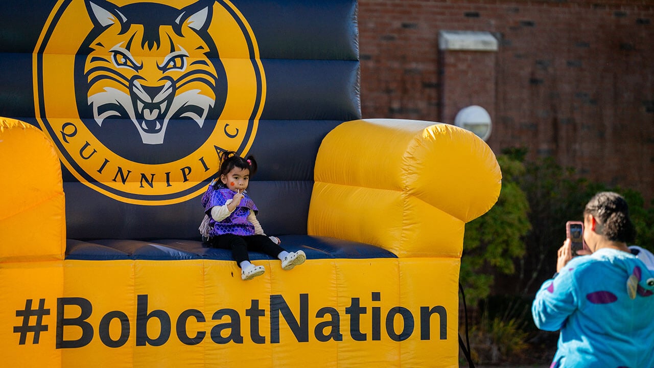 A little girl sitting on the Bobcat Nation inflatable chair