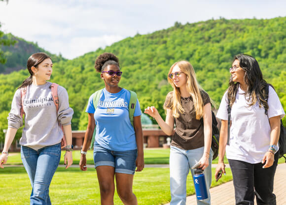 4 female students walking outside on campus