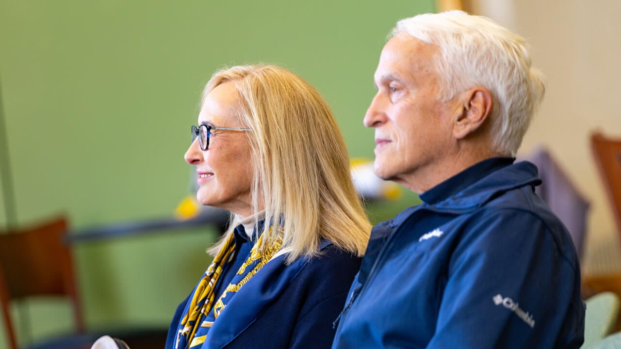 President Marie Hardin smiling as she looks up to the presenters at the indigeneity initiative teach in