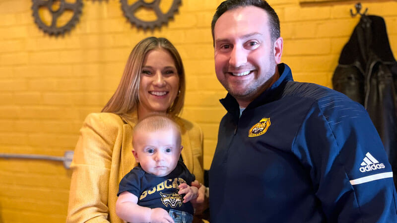 The distasio's holding their baby in Quinnipiac colors