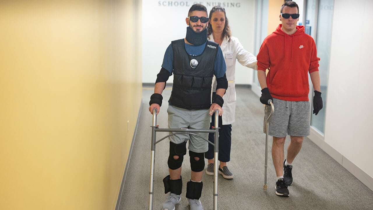 Nursing students engage in a learning activity using wearables that simulate disabilities and limitations of patients to better understand what their patients might be experiencing.