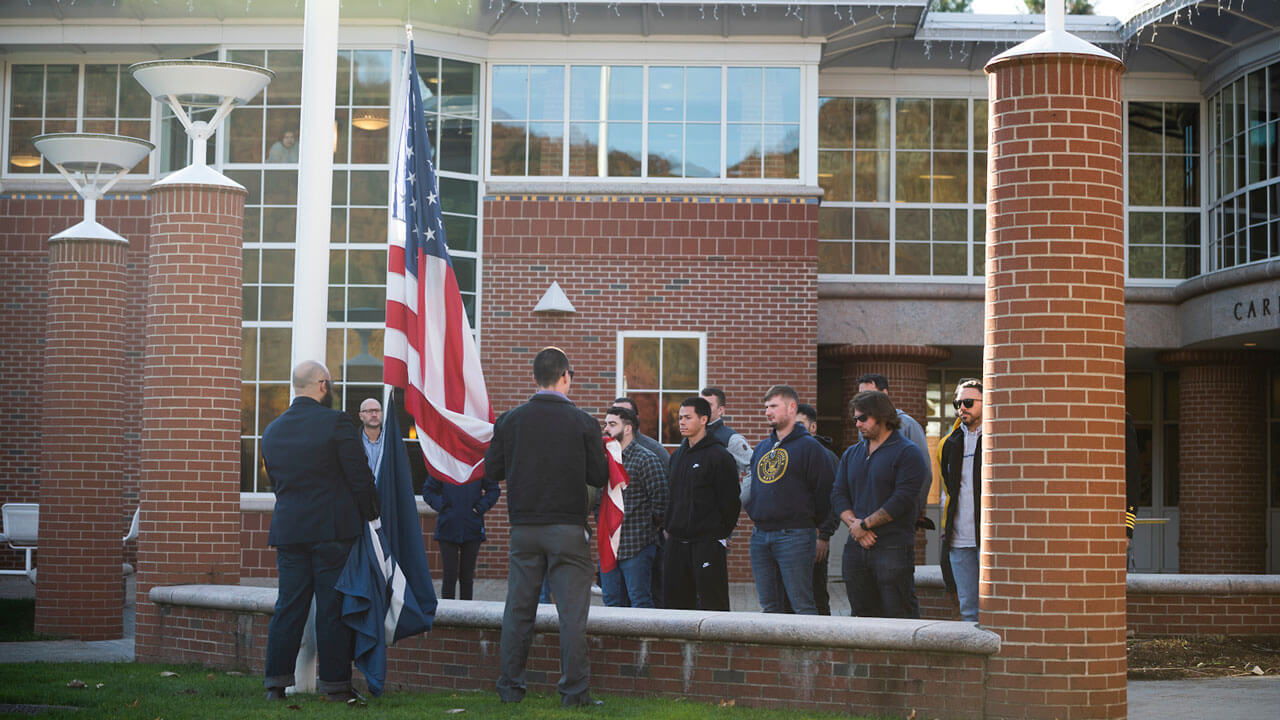 Veterans gather and lower the flag at the ceremony