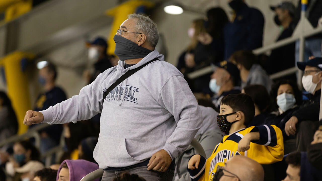 Dad standing up in crowd while watching a hockey game