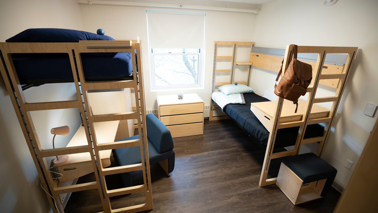 Bunkbed and lofted bed and desk in residence hall bedroom