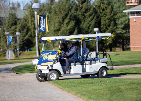 The conduct cab drives around campus in front of the CCE pond