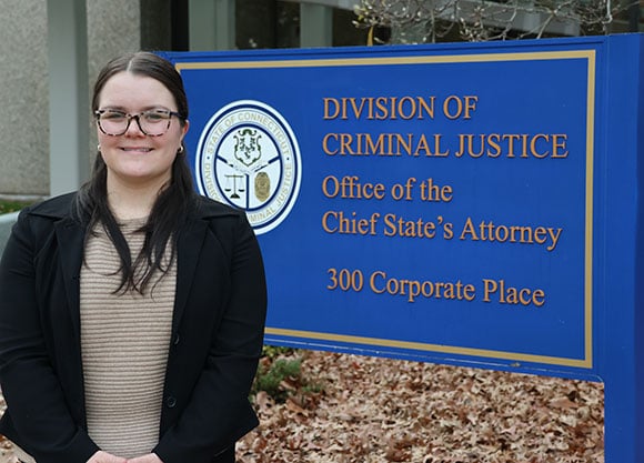 Graduate Olivia Hally stands in front of the Office of the Chief State’s Attorney
