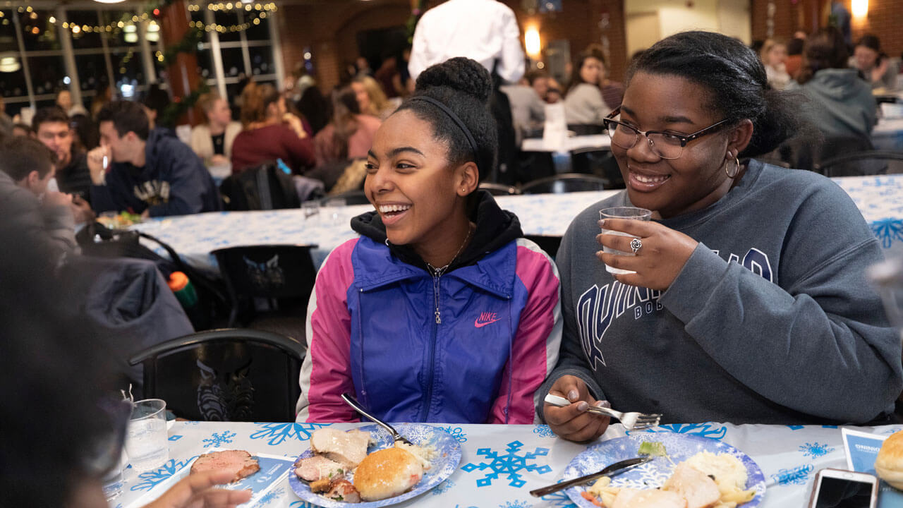 Students laugh together as they eat turkey during the holiday dinner