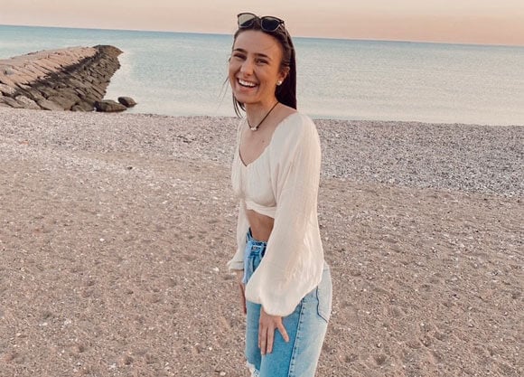 Grace Stickel smiling and standing at beach