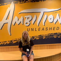 Eileen Sheridan in front of an "Ambition Unleashed" sign
