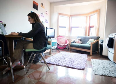 A student works at her laptop in the common room of her apartment in Crescent