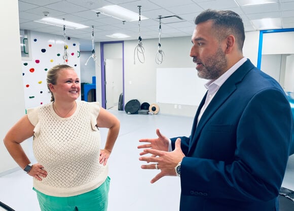 Two Quinnipiac occupational therapy alumni talk together in a bright, cheerful room