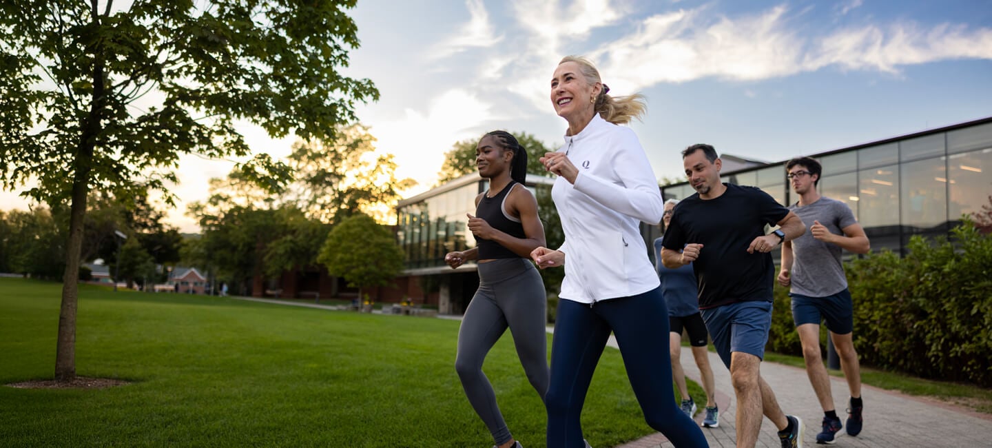 Marie Hardin and students run by the RecWell at sunset