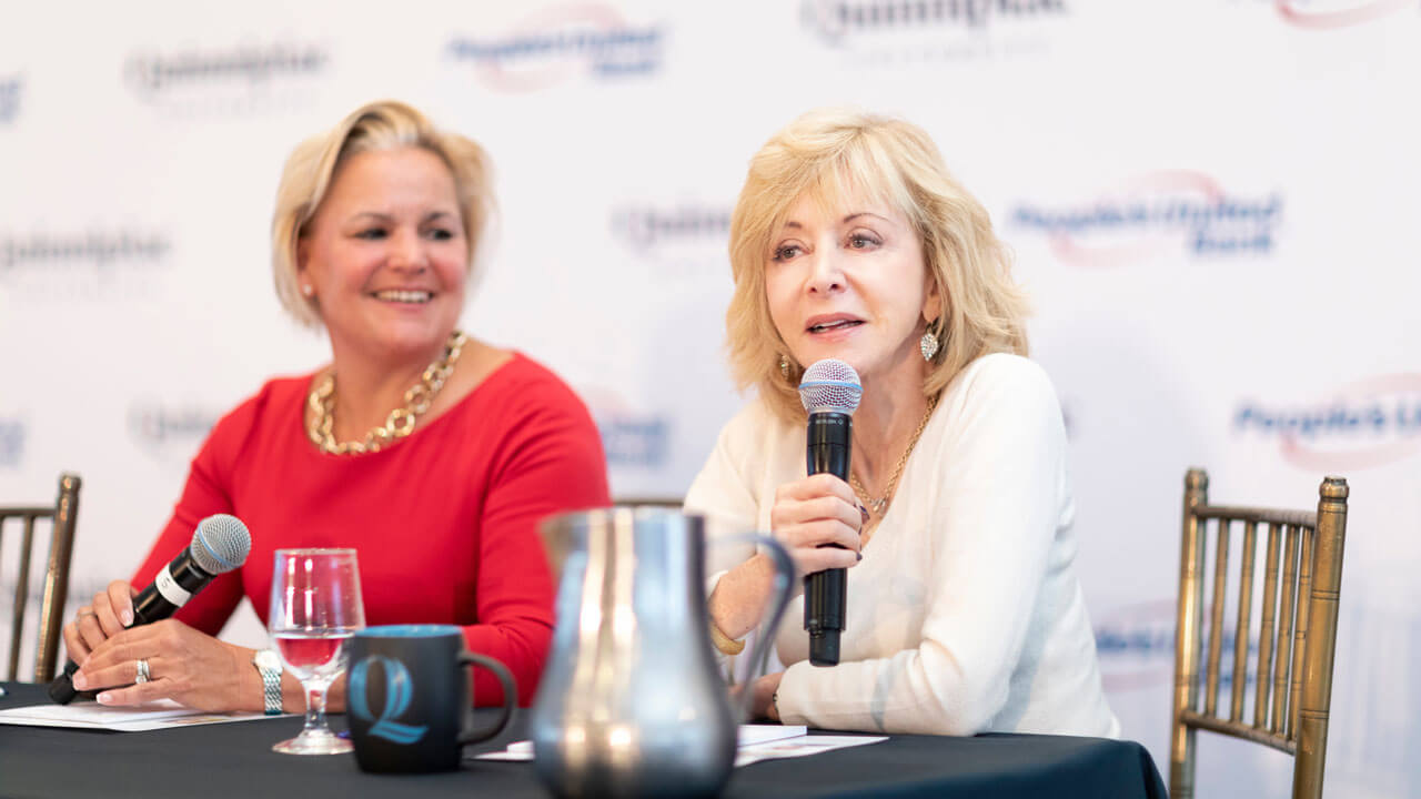 Judy Olian and Sara Longobardi speak at a table during a women in leadership event