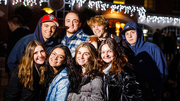 A group of students outside at the Quad Holiday Lighting.