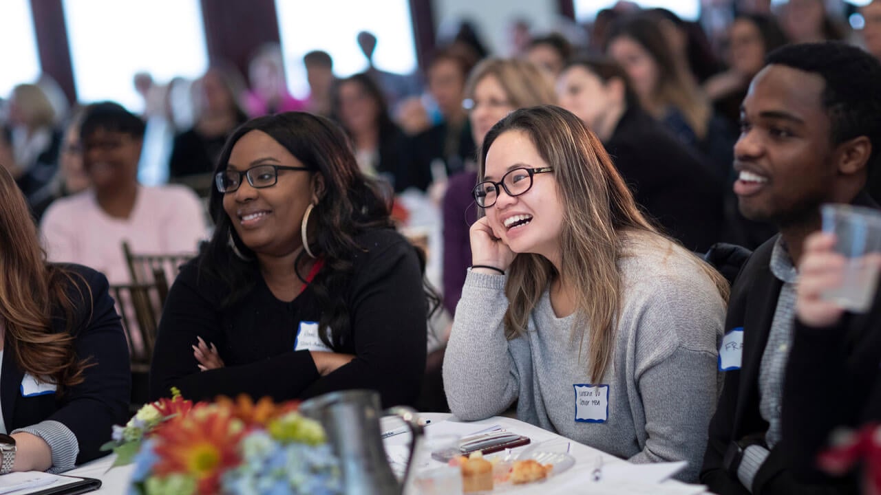 Several students laugh during a Quinnipiac women and business event