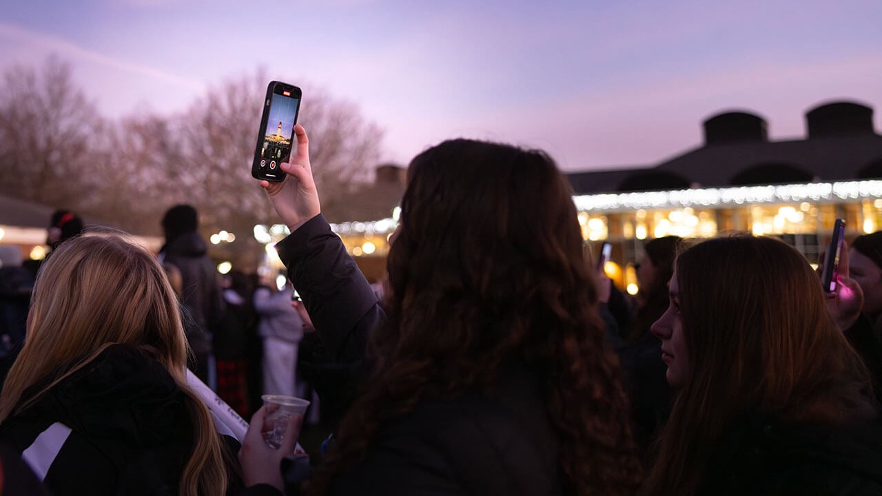 Student takes a video of the Quad Lighting on iPhone